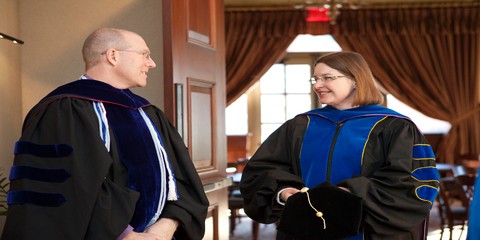 Christine Rener converses with faculty member before the ceremony